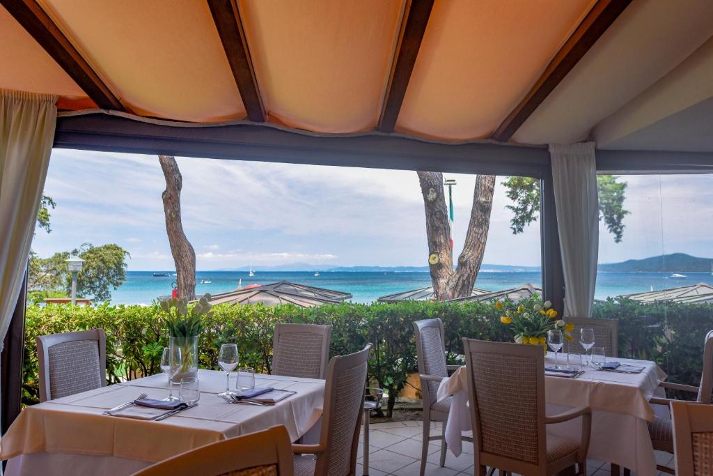 une salle à manger avec vue sur l'océan dans l'établissement La Bussola Beach Hotel, à Punta Ala