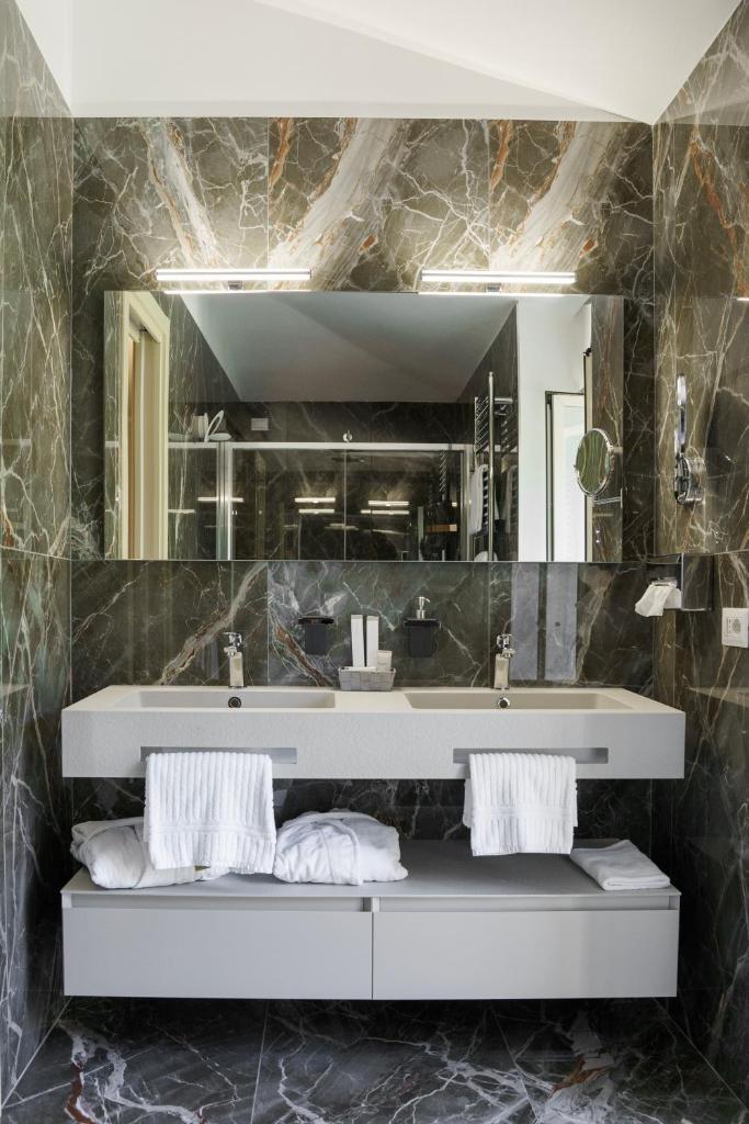 une salle de bain avec un lavabo et un miroir dans l'établissement Hotel Villa Paradiso, à Arona