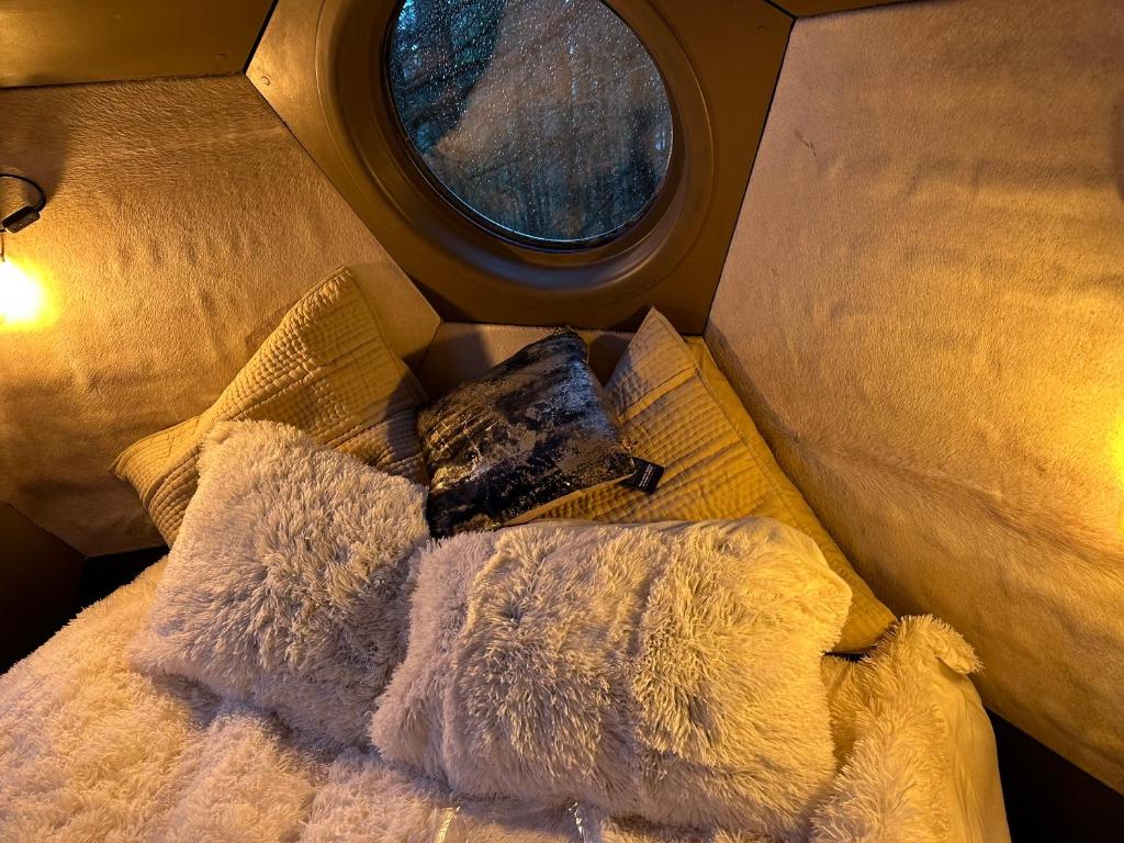 Cette chambre comprend un lit avec des oreillers et une fenêtre. dans l'établissement Mirror globe Kandasphere, à Saint-Gervais-les-Bains