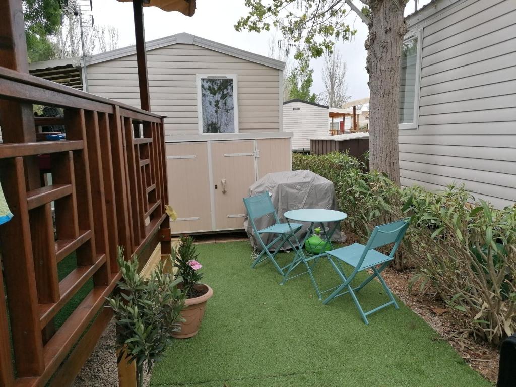 d'une terrasse avec 2 chaises et une table sur gazon. dans l'établissement Mobil home 2 chambres camping 4 étoiles vias, à Vias