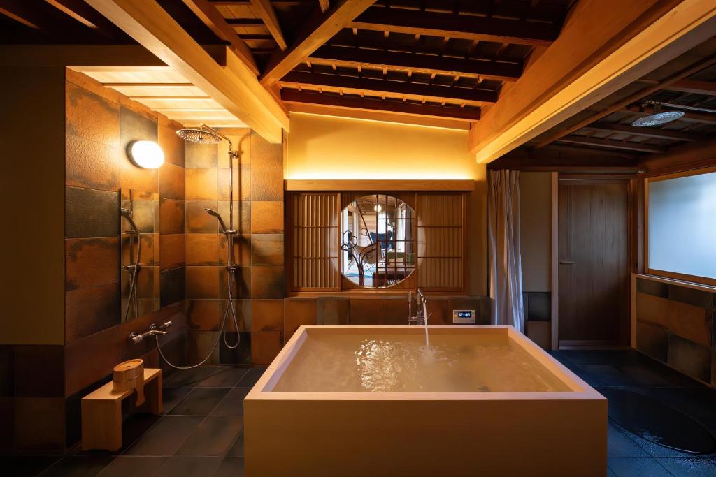 La grande salle de bains est pourvue d'une baignoire et d'une télévision. dans l'établissement Sekitei, à Hatsukaichi