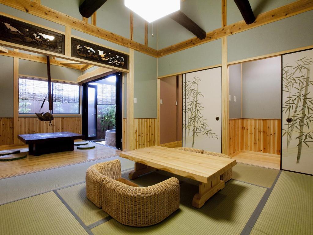 un salon avec une table et des chaises en bois dans l'établissement 徳の宿 ふぶ庵, à Beppu