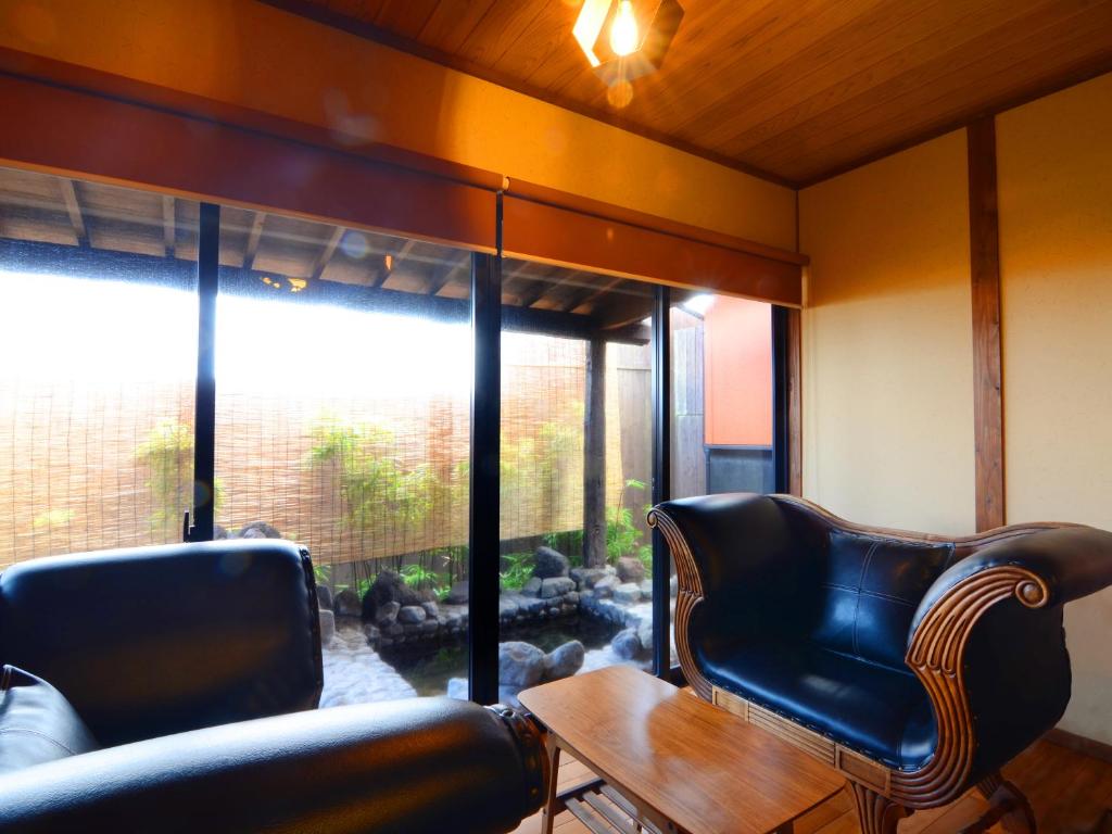 un salon avec deux chaises et une table dans l'établissement 徳の宿 ふぶ庵, à Beppu