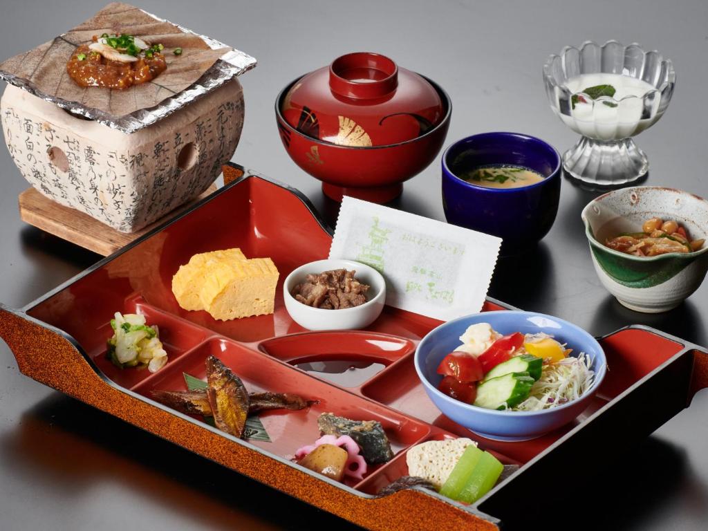 - une table avec un plateau de nourriture et des bols de nourriture dans l'établissement Tabist Ryokufuen Kiyoharu, à Takayama