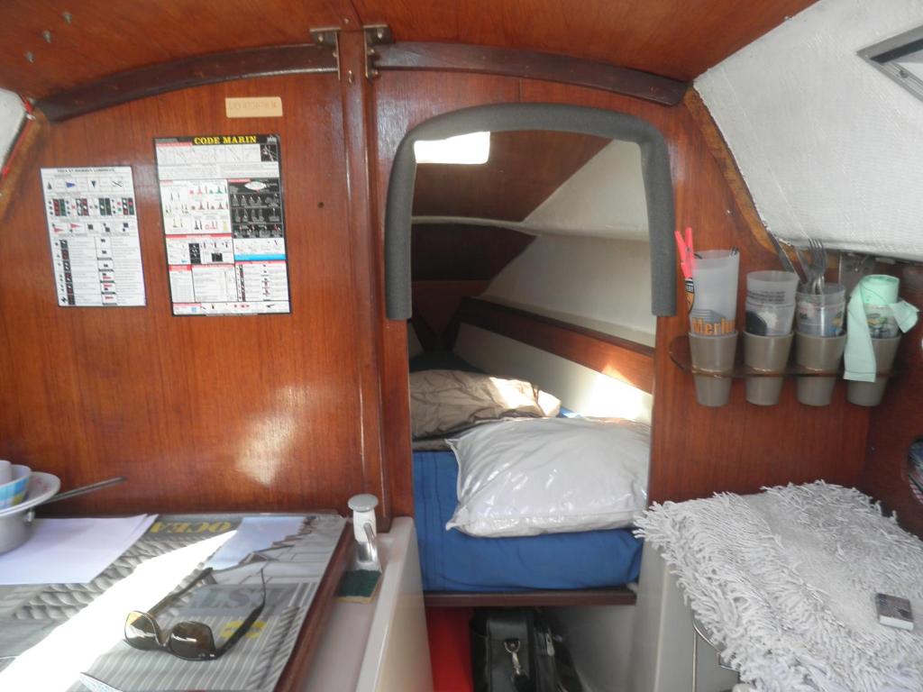 une petite chambre avec un lit et un miroir dans l'établissement Voilier NEVEN, à Lorient