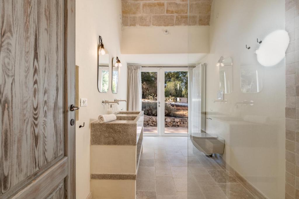 une salle de bain avec un lavabo, des toilettes et un miroir dans l'établissement Dimora Donnagnora, à Ostuni
