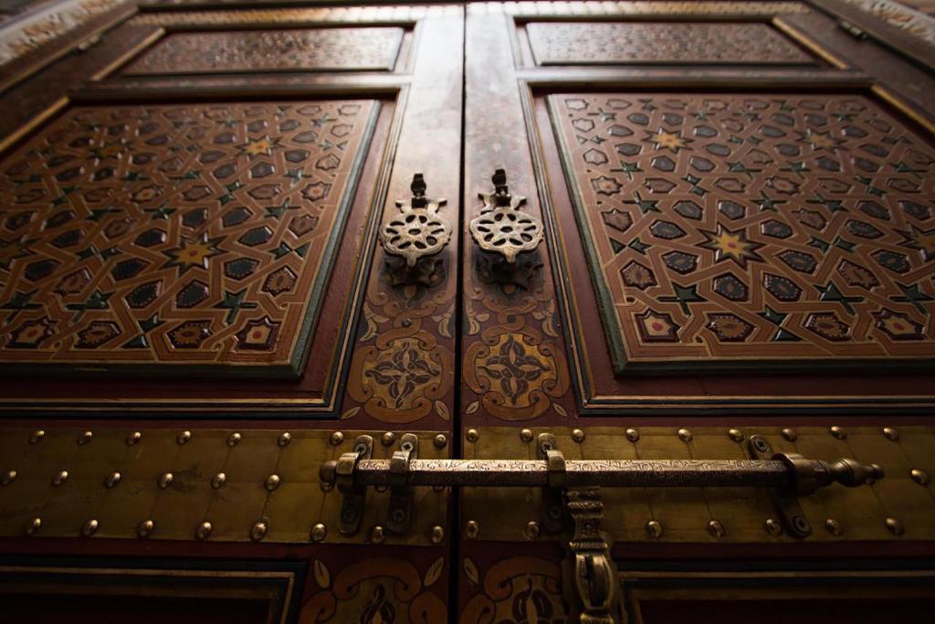 une porte en bois aux motifs complexes dans l'établissement Dar Ahl Tadla, à Fès