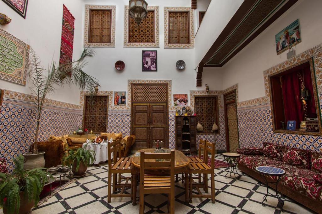un salon avec des canapés, une table et des chaises dans l'établissement Dar Ahl Tadla, à Fès