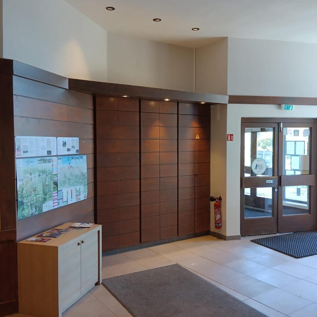 un hall de bureau avec un grand mur en bois dans l'établissement Ski-in ski-out 1 bed, La Tania, à Courchevel