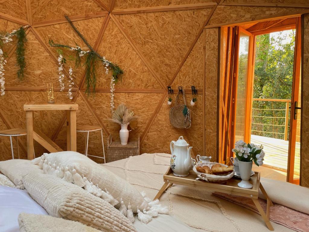 une pièce avec un lit et une table avec de la nourriture dessus dans l'établissement L'étoile de Baynes, à Cerisy-la-Forêt