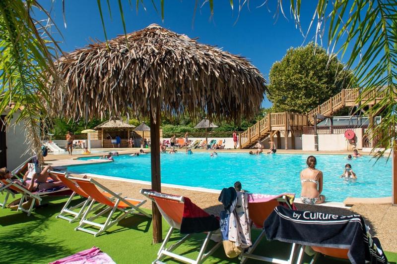 - une piscine avec des chaises et un parasol dans l'établissement Camping Parc Mogador, à Sanary-sur-Mer