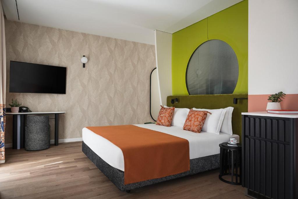 une chambre d'hôtel avec un lit et une télévision à écran plat dans l'établissement DuoMo Hotel, à Rimini