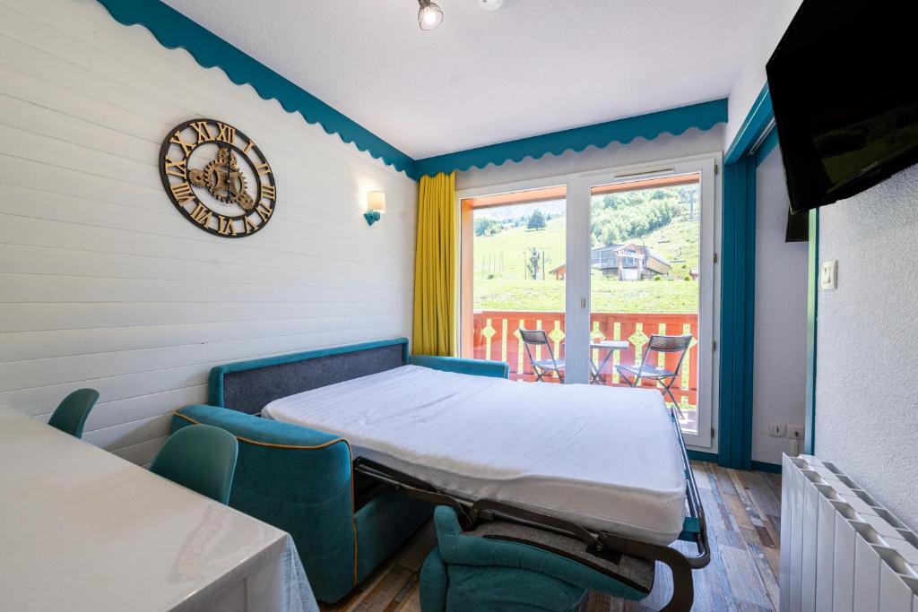 une salle d'hôpital avec un lit, des chaises et une horloge dans l'établissement Appartement 6 personnes, à Saint-François-Longchamp