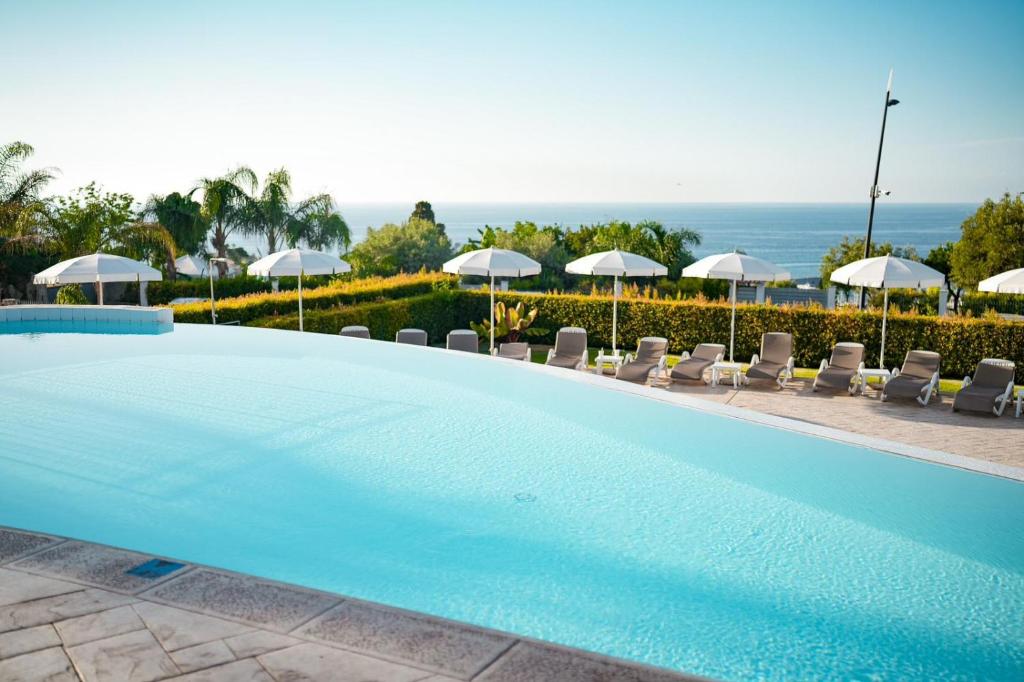 une grande piscine avec chaises et parasols dans l'établissement Sentido Michelizia Tropea Resort, à Tropea