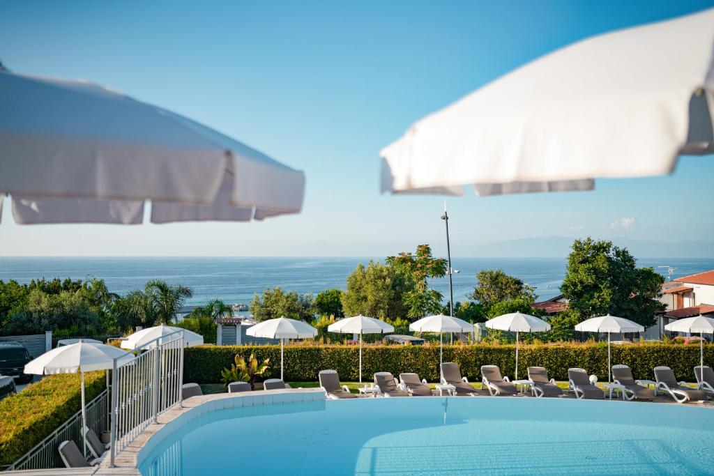une vue sur une piscine avec chaises et parasols dans l'établissement Sentido Michelizia Tropea Resort, à Tropea