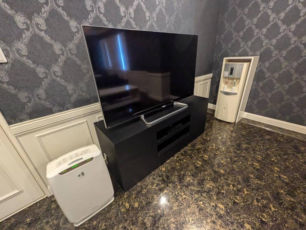 Une grande télévision à écran plat est installée au-dessus d'un comptoir. dans l'établissement Carnet (Adult Only), à Amagasaki