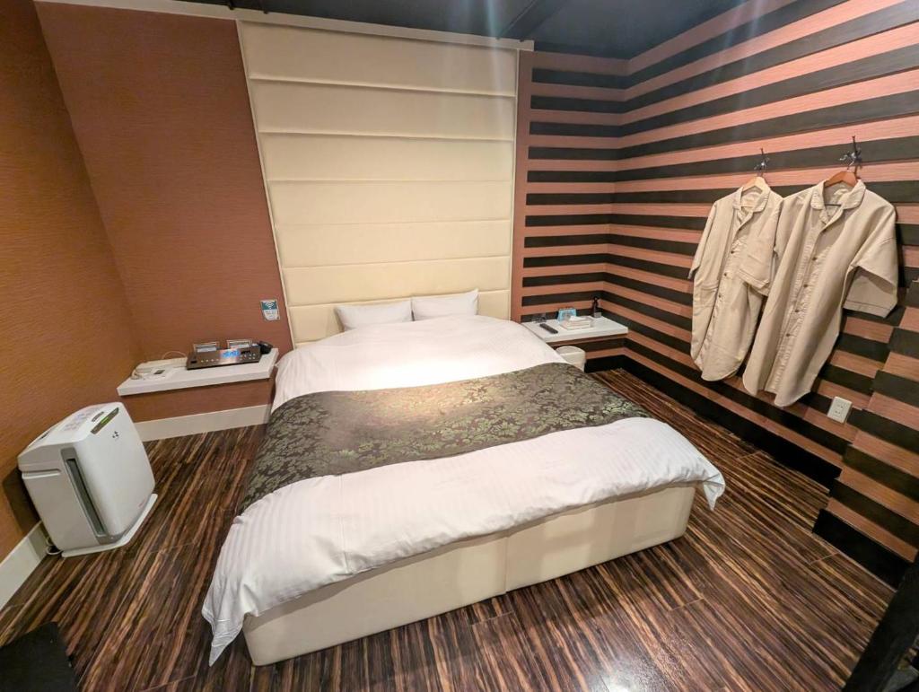 une chambre avec un grand lit dans une pièce dans l'établissement Carnet (Adult Only), à Amagasaki