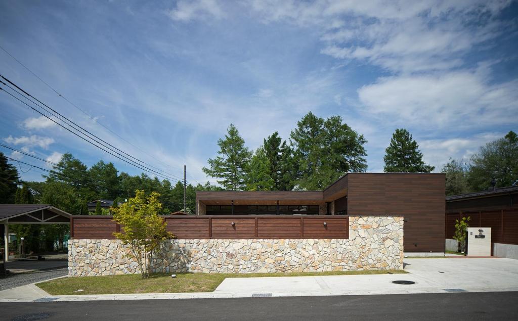 une maison avec un mur de pierre dans l'établissement Private Villa Glampimg 富士山中湖, à Yamanakako