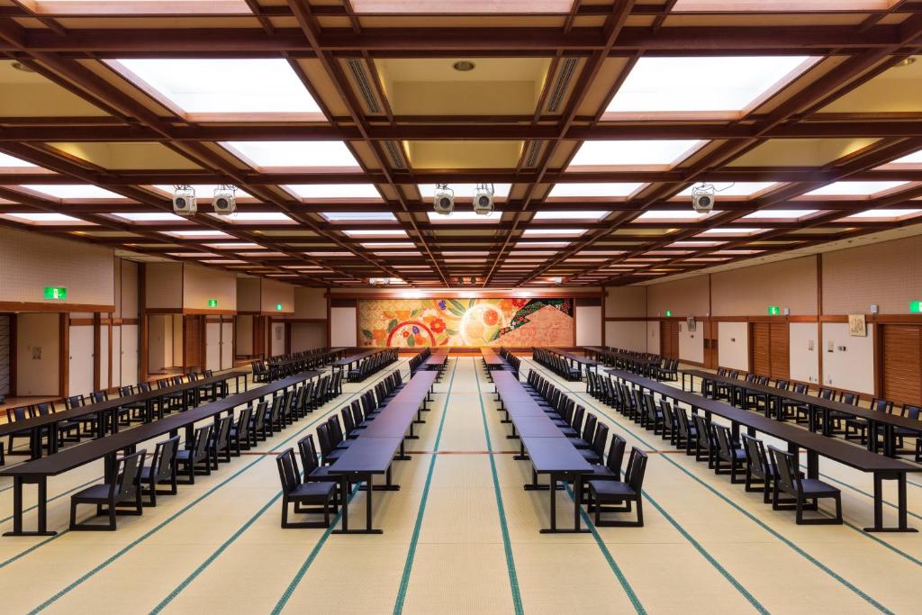 Cette grande chambre dispose de rangées de chaises et d'une peinture murale. dans l'établissement Mikazuki Sea-Park Hotel Katsuura, à Katsuura