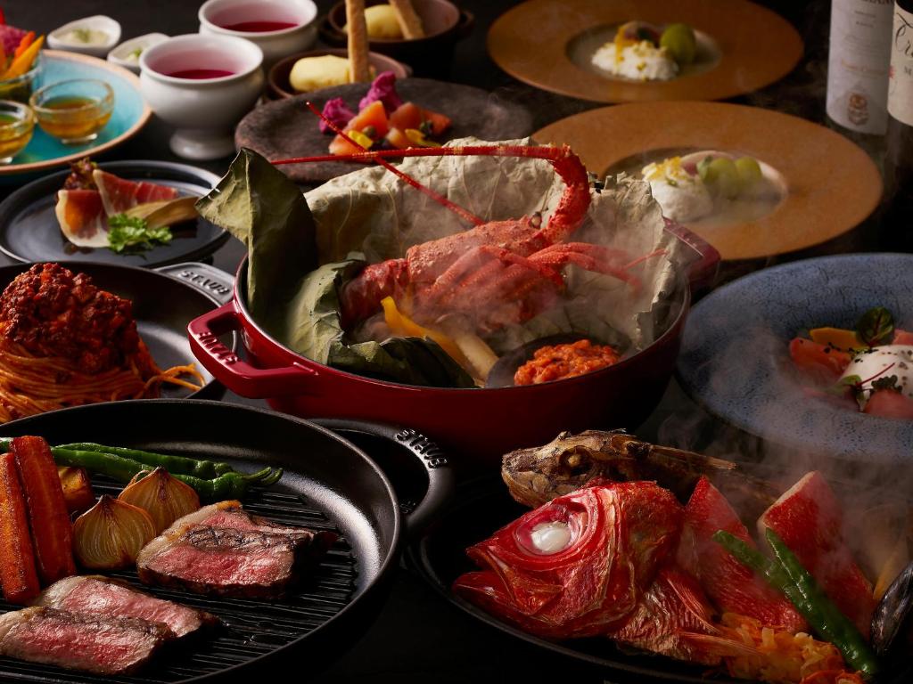 une table contenant de nombreux types de denrées alimentaires différents dans l'établissement Atagawa Ocean Resort, à Higashiizu