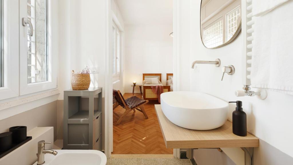 La salle de bains est pourvue d'un grand lavabo blanc et de toilettes. dans l'établissement ANTICO CERASO 10, Emma Villas, à Grottaferrata