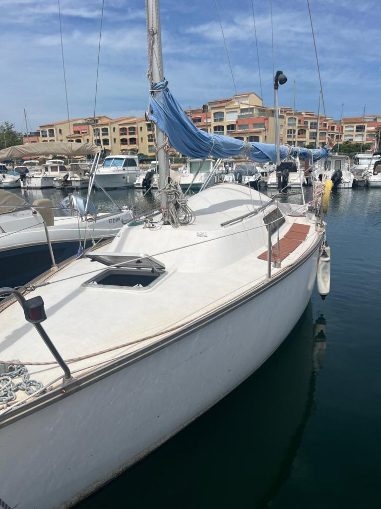 un voilier blanc amarré dans un port avec d'autres bateaux dans l'établissement Voilier et plage, au Cap d'Agde