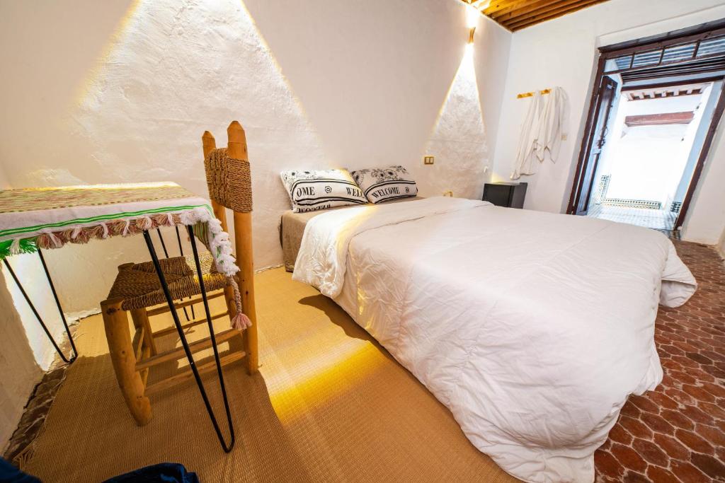 une chambre avec un grand lit dans une pièce dans l'établissement Riad Mtamer, Tetouan, à Tetouan