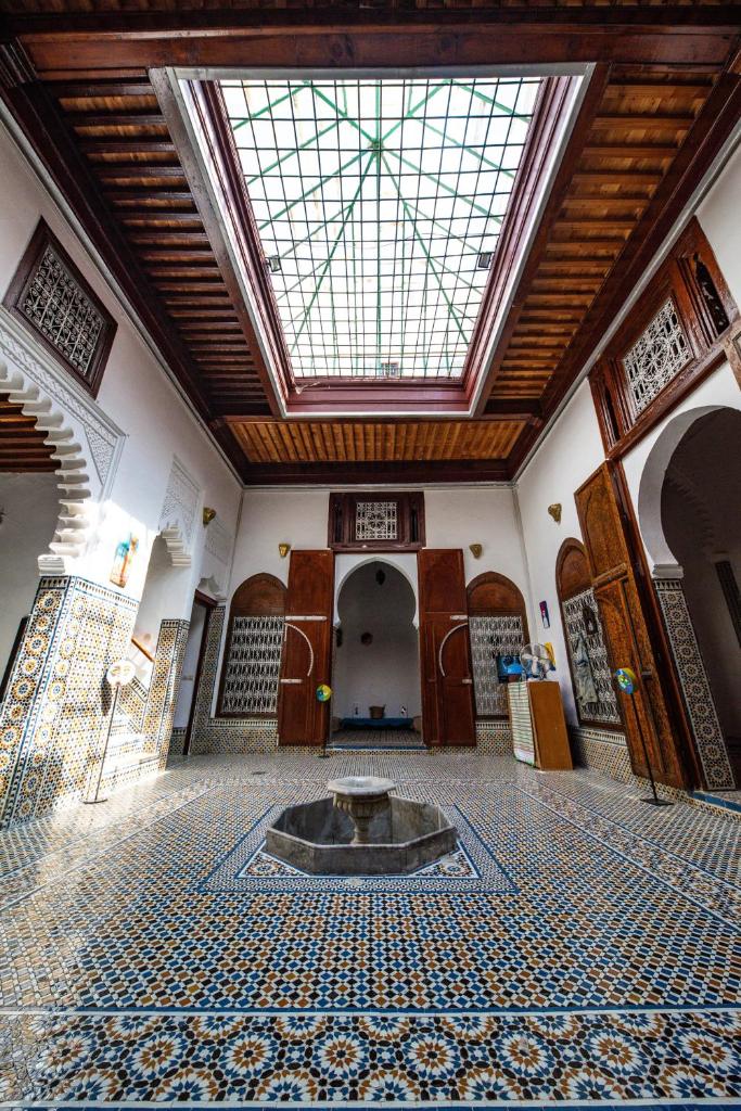 une grande chambre avec une fontaine au milieu d'un bâtiment dans l'établissement Riad Mtamer, Tetouan, à Tetouan