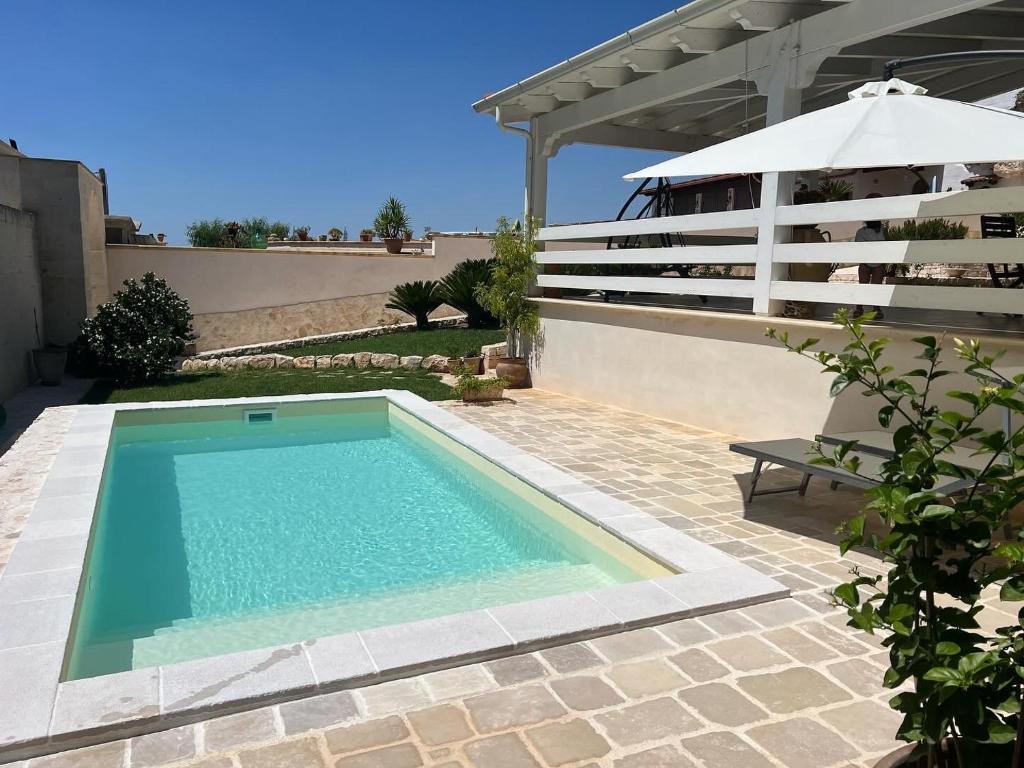 - une piscine sur une terrasse avec un parasol dans l'établissement MASSERIA FRANTELLA, à Grottaglie
