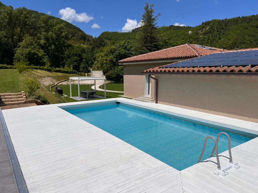 une piscine devant une maison dans l'établissement Al Quadrato, à Piobbico
