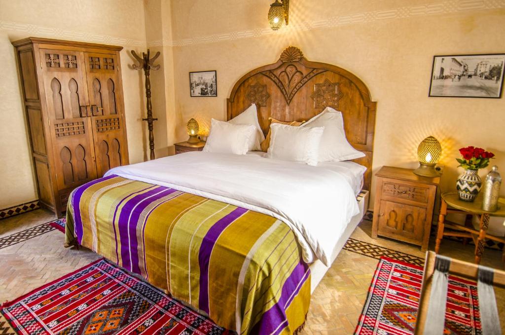 une chambre avec un grand lit avec une tête de lit en bois dans l'établissement Riad Sidi Fatah, à Rabat