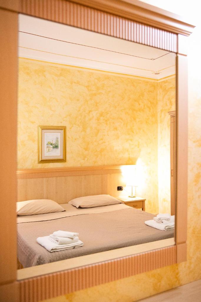 une chambre avec un lit dans un miroir dans l'établissement Mannu Hotel, à Bosa