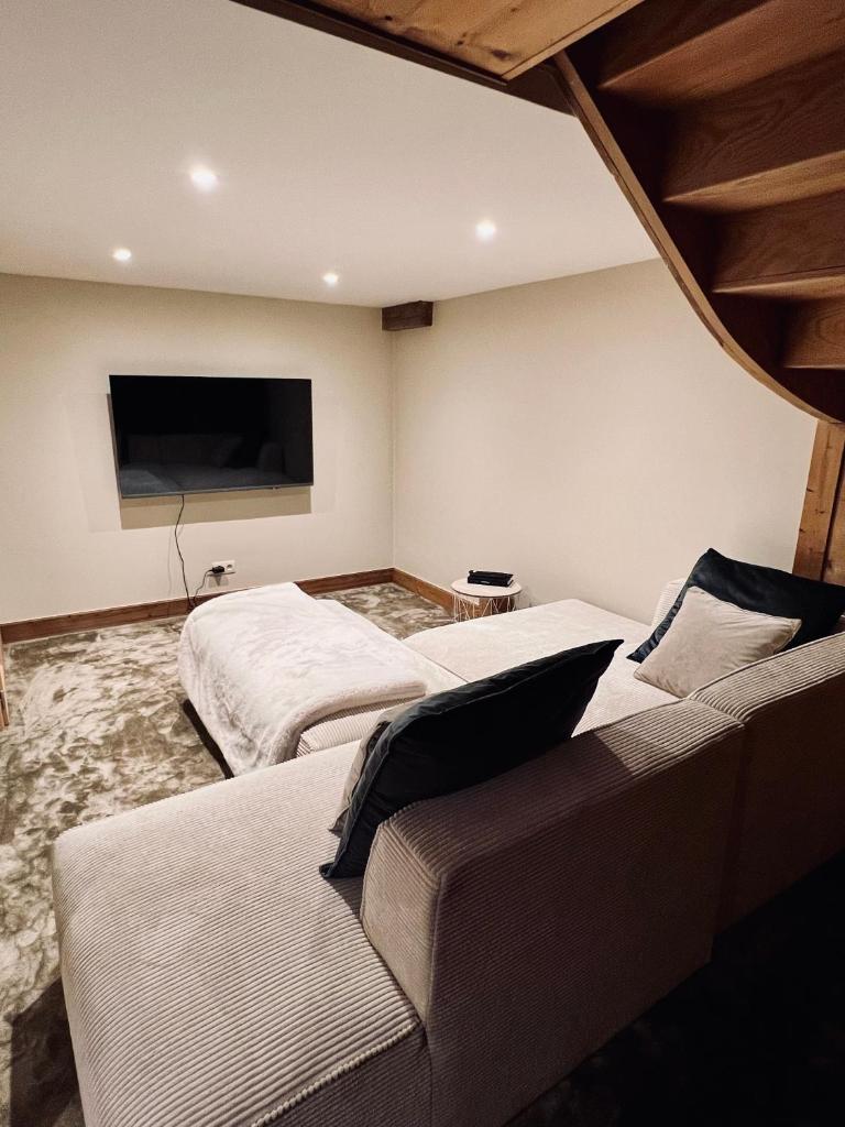 Cette chambre comprend deux lits, un canapé et une télévision à écran plat. dans l'établissement Alpine Retreat with Mont Blanc View, Chamonix, private parking, à Chamonix-Mont-Blanc