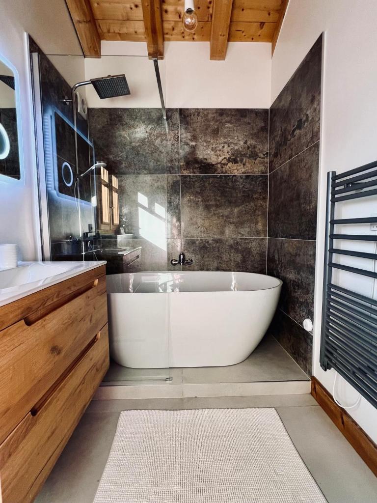 une salle de bain avec une baignoire blanche et un lavabo dans l'établissement Alpine Retreat with Mont Blanc View, Chamonix, private parking, à Chamonix-Mont-Blanc