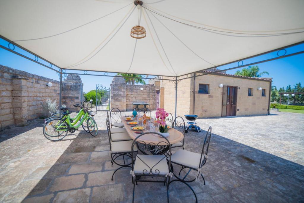 une table et des chaises sous une tente blanche dans l'établissement Masseria Relais Saraceno With Pool - Happy Rentals, à Melendugno