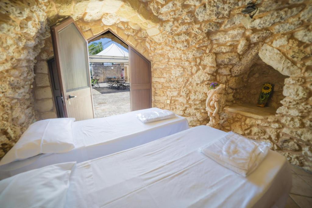 une chambre avec un lit dans un mur de pierre dans l'établissement Masseria Relais Saraceno With Pool - Happy Rentals, à Melendugno 38 autres photos