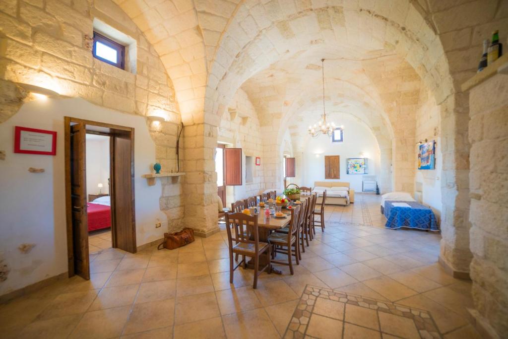 une pièce avec une table et des chaises dans un bâtiment dans l'établissement Masseria Relais Saraceno With Pool - Happy Rentals, à Melendugno