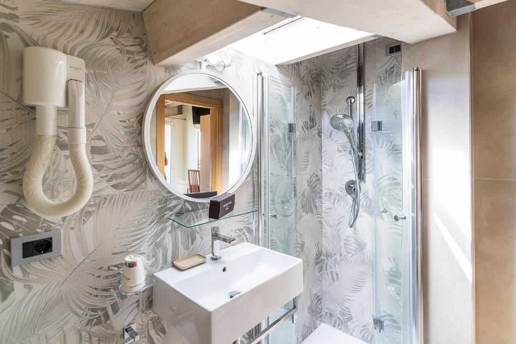 une salle de bain avec un lavabo et un miroir dans l'établissement Melody Hotel, à Cervia