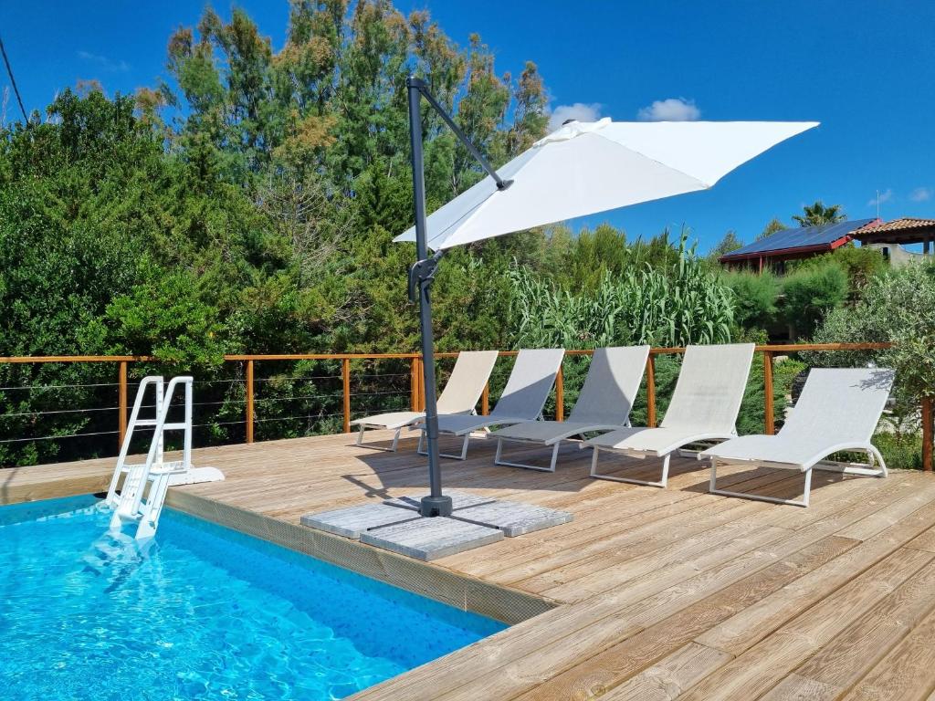 - une piscine avec des chaises blanches et un parasol dans l'établissement Villa I Tamarigi, à Maruggio