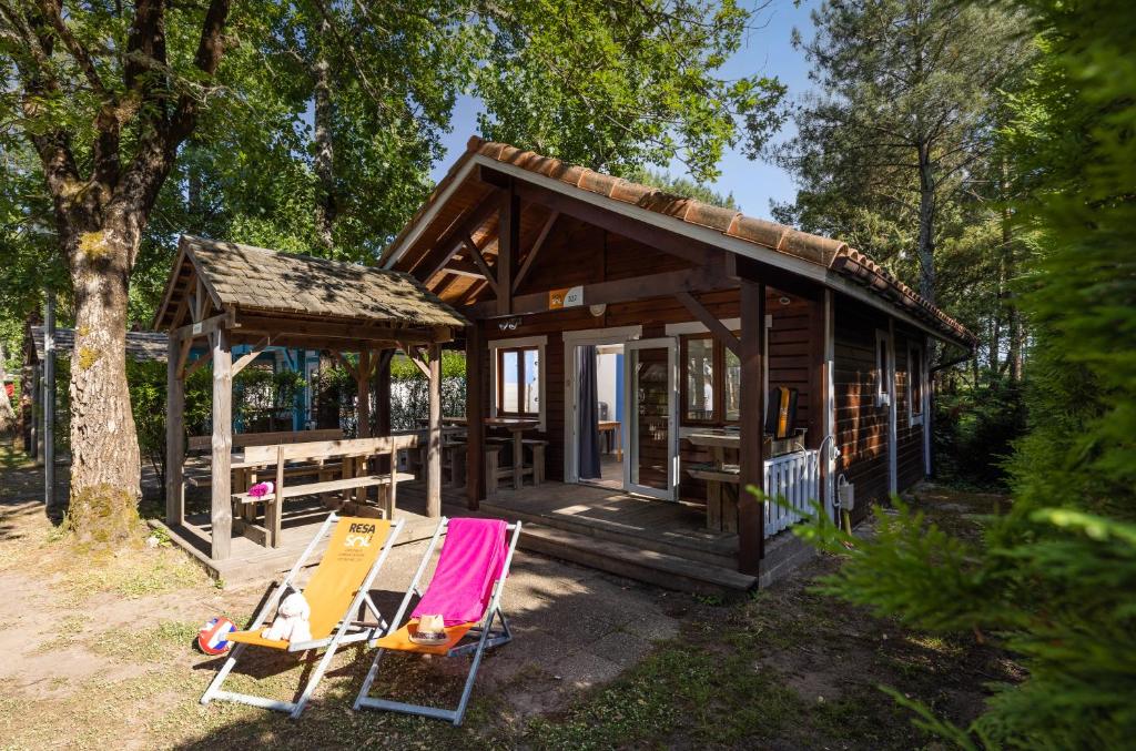 une petite cabine avec deux chaises devant elle dans l'établissement Camping Village Le Vieux Port*****, à Messanges