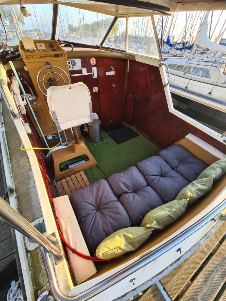 un petit bateau avec des sièges violets au milieu dans l'établissement Bateau, à Ouistreham