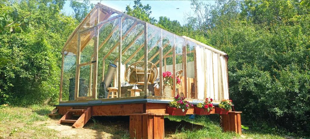 une serre en verre avec des fleurs sur une table dans l'établissement Insolite Cabane du Rêveur, à Pagny-sur-Moselle 19 autres photos