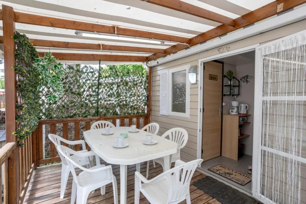 un patio avec une table et des chaises sur une terrasse dans l'établissement Mobil-homes proche de l'océan, à Saint-Jean-de-Monts