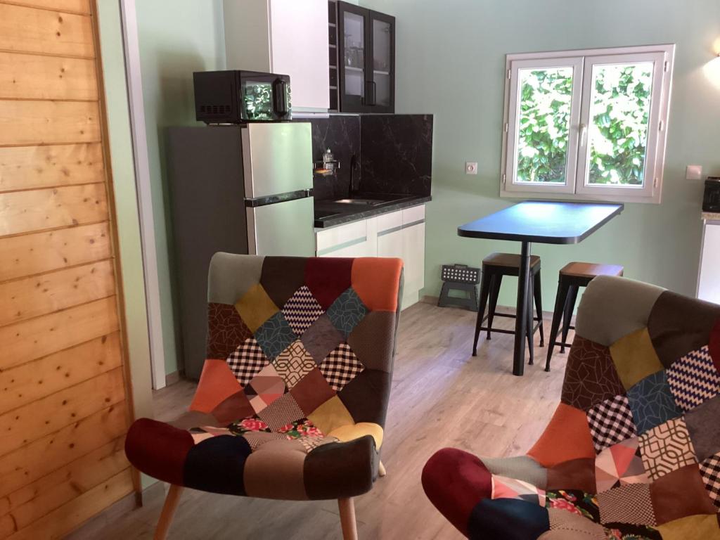 une cuisine avec deux chaises et une table dans l'établissement Chalet de luxe bord de riviere, à Pont-de-Labeaume