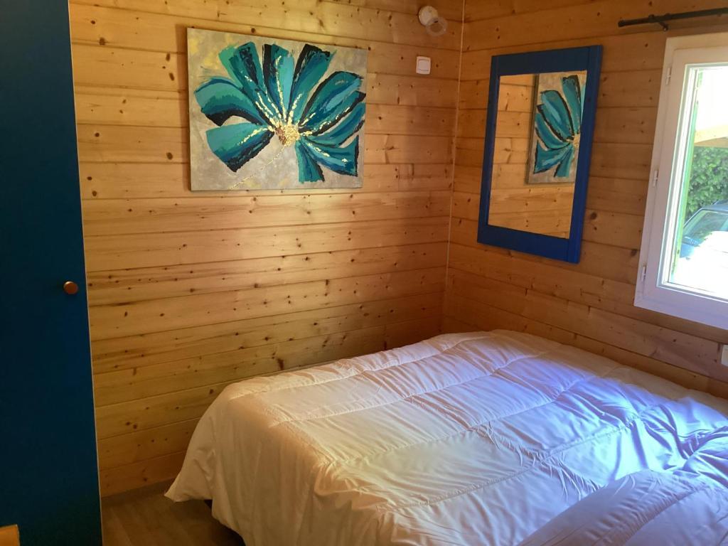 une chambre avec un lit dans un mur en bois dans l'établissement Chalet de luxe bord de riviere, à Pont-de-Labeaume
