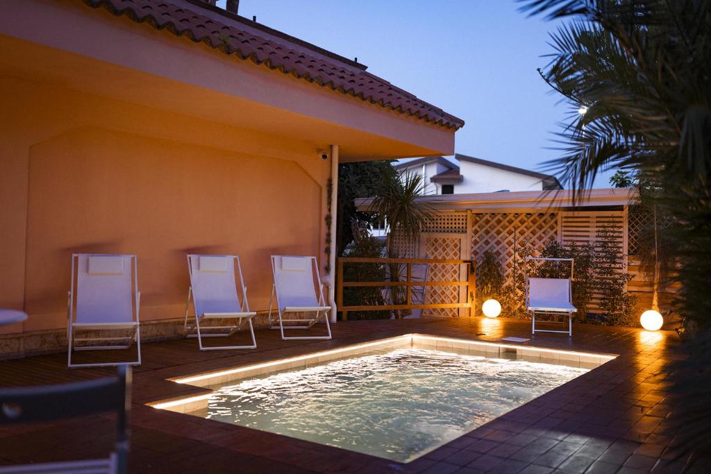 un patio avec des chaises et une piscine dans l'établissement Hotel Ristorante Le Rose, à Briatico