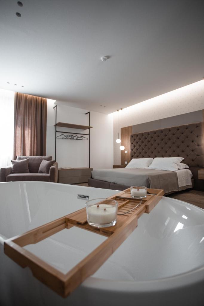 une salle de bain avec baignoire dans une chambre dans l'établissement Alexander House Hotel, à San Ferdinando