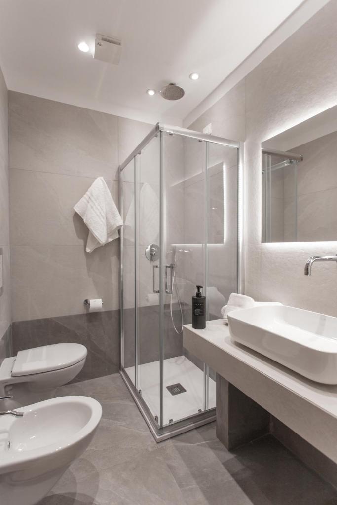 une salle de bain avec une douche en verre et un lavabo dans l'établissement Alexander House Hotel, à San Ferdinando