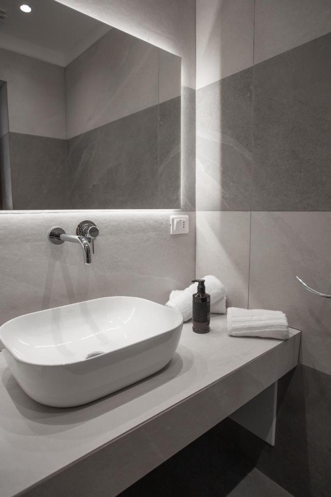 une salle de bain avec un lavabo blanc et un miroir dans l'établissement Alexander House Hotel, à San Ferdinando 63 autres photos