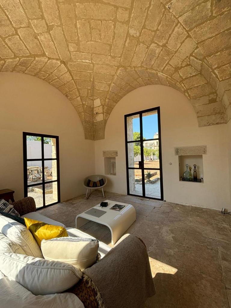 un salon avec un canapé et une table dans l'établissement Casa Corte - Palazzo Villani Lubelli, à Cannole